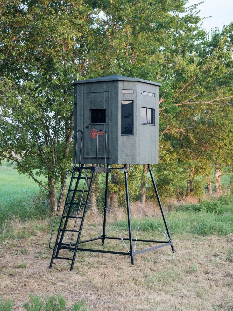 Black box blind on a tall metal tripod at the edge of a field, with a ladder for access